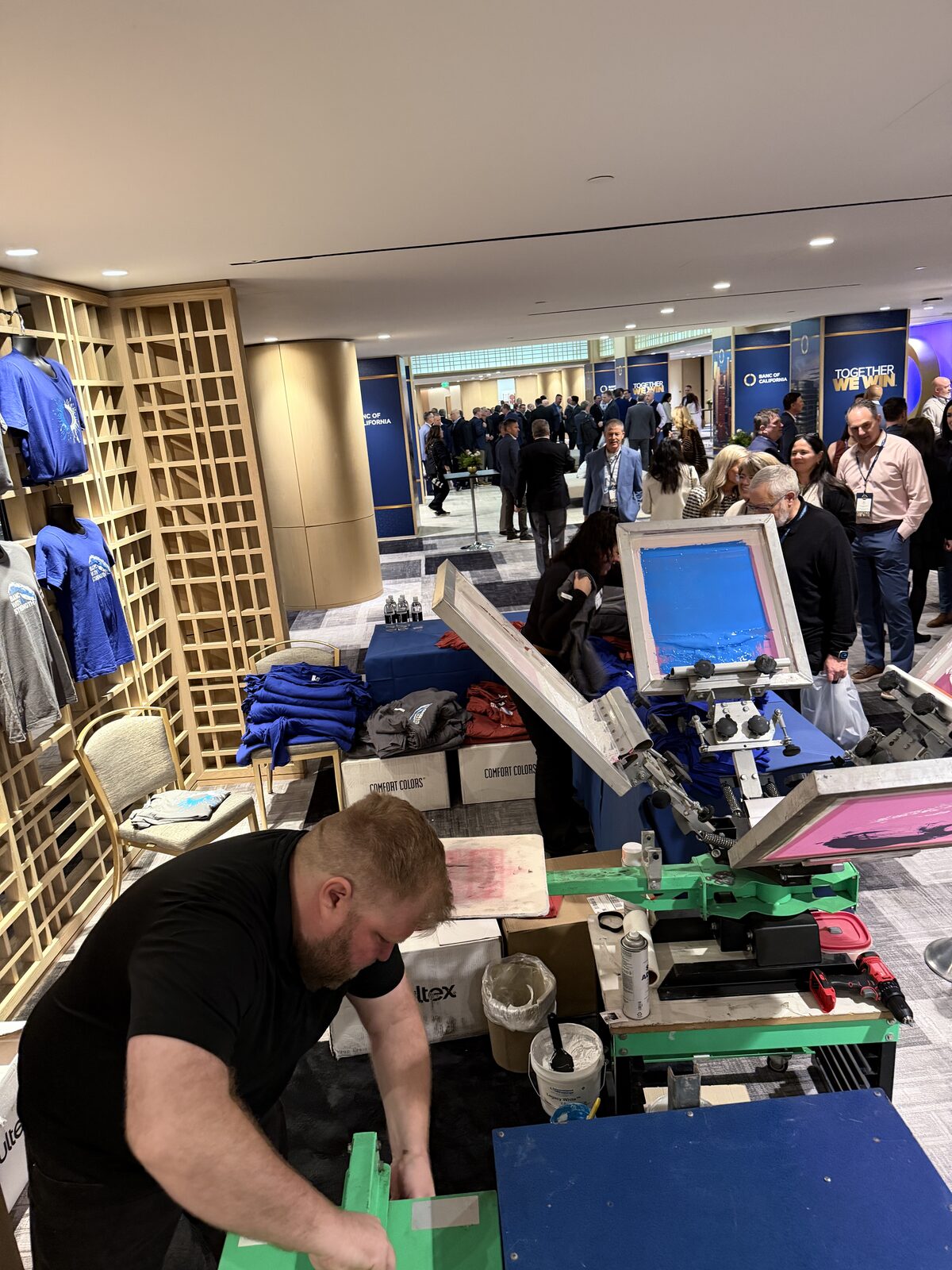 Guests watching a printer pull a squeegee at a Orange County event